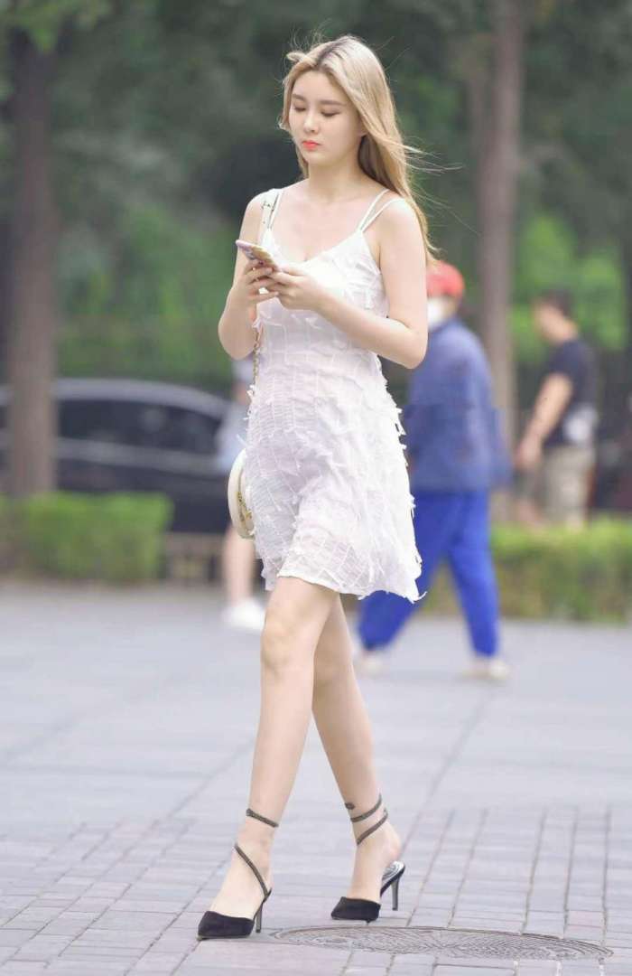 图中小姐姐身穿白色吊带连衣裙, 干净又清爽