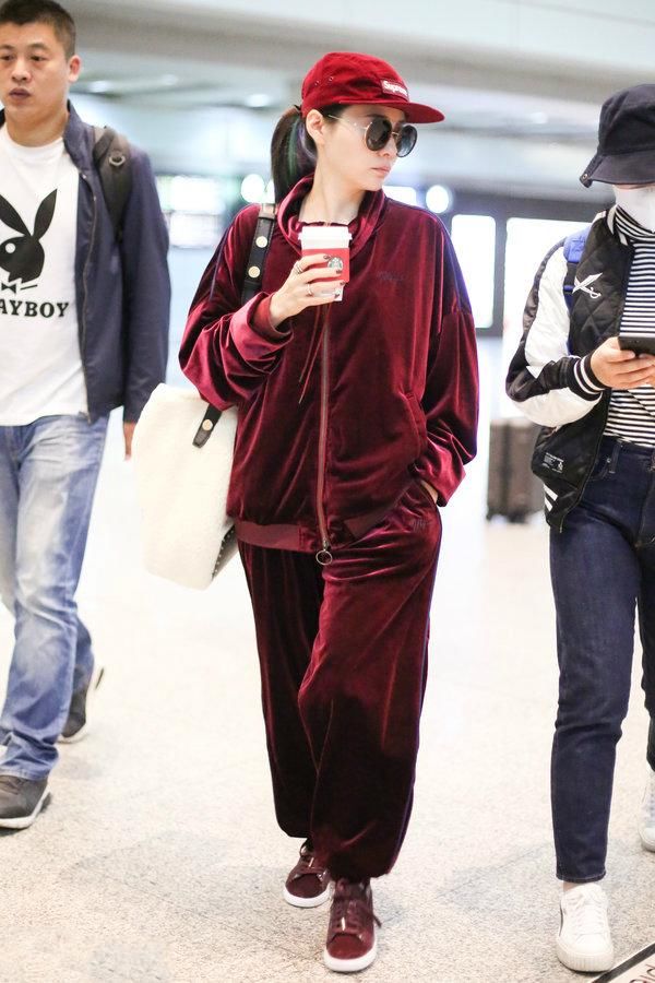张靓颖机场秀从头到脚都是时下最潮的酒红色，网友:简直就是灾难