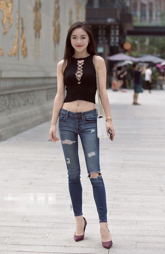 路人街拍，小姐姐上身穿的是一件无袖的露脐紧身上衣，身材真好看