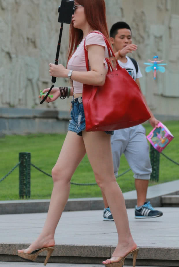 丰腴小姐姐紧身衣裹出呼之欲出的圆润曲线，身后玩芭比的小哥很抢