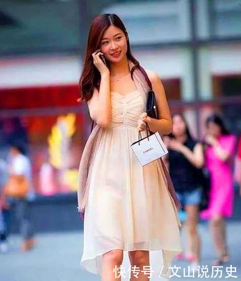  面带微笑：街拍面带微笑的美女，一条白色的连衣裙，时尚靓丽气息