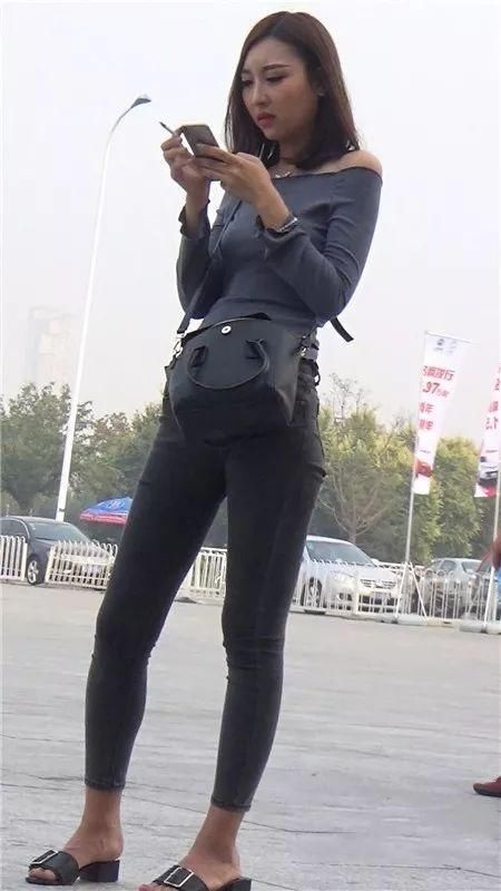 紧身露肩上衣搭配贴身牛仔裤，简约时尚