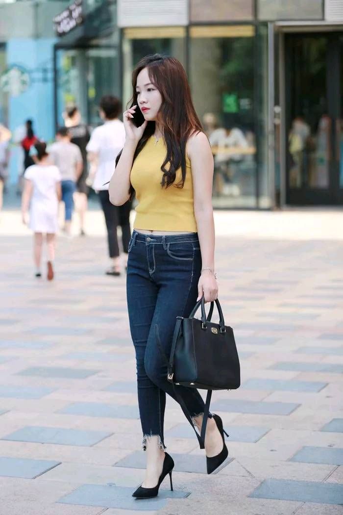 路人街拍，时尚的无袖上衣搭配干练的牛仔裤，打造出你的窈窕身姿