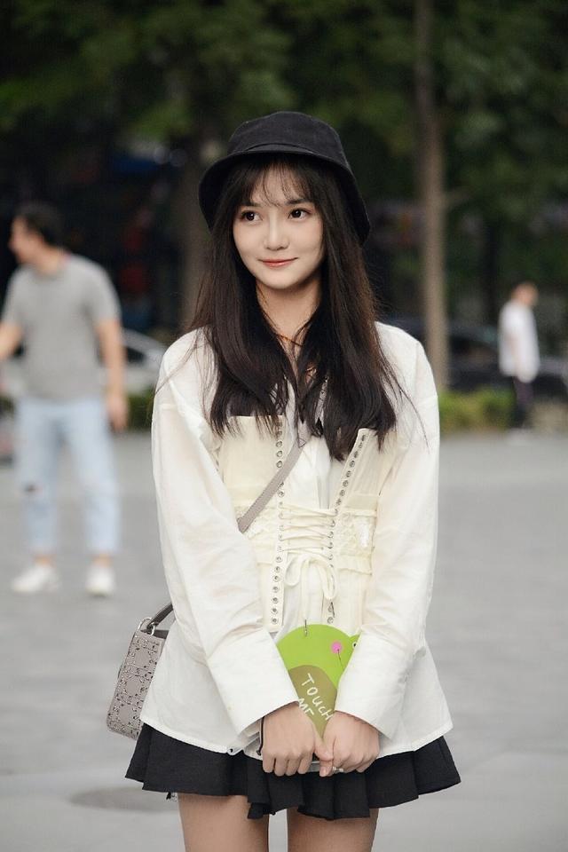 路人街拍，小姐姐身穿一件黑色的短裙，看上去非常的清纯可爱