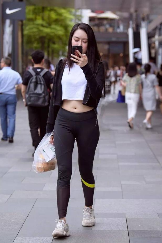街拍：紧身打底裤的姐姐，搭配短t恤组成露脐装，超显魅力又迷人