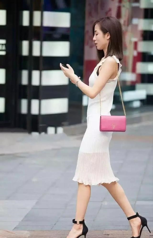  显得：街拍：小姐姐一件白色的紧身短连衣裙，显得清纯可人