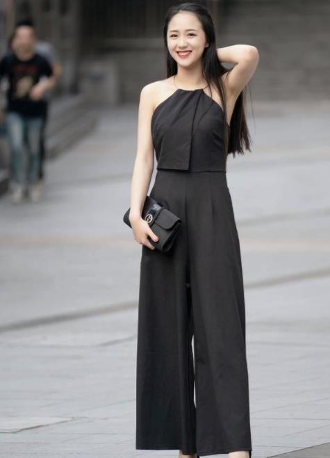 小美女:街拍:小美女身穿黑色套装,手里拿着包包,笑容甜美