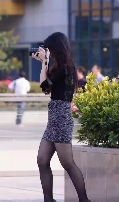 时尚御姐黑色衬衫搭配包臀裙，身材凹凸有致，玩起拍照笑逐颜开可